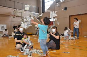 新聞紙をやぶいて遊んでいる写真