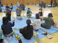 昭和小の生徒達が体育館でお飾り作りをしている様子の写真