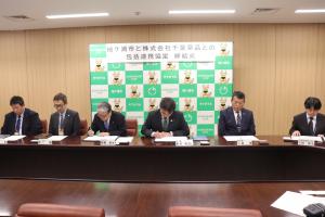 協定書に署名する粕谷市長