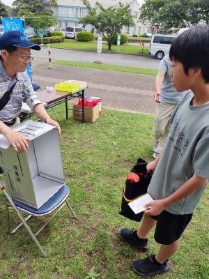 投票箱の中に何も入っていないことの確認をしてもらっている写真