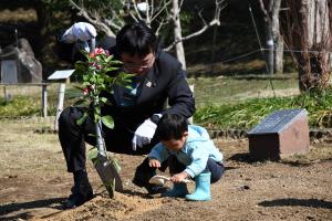 市長と来館者100万人目の根本さんの記念植樹の様子