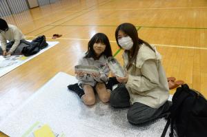 新聞紙のカレー皿を持っている親子の写真