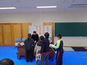 講師に書いた文字を見てもらう子供達の写真