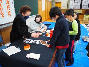 手本を見せてもらう子供の写真