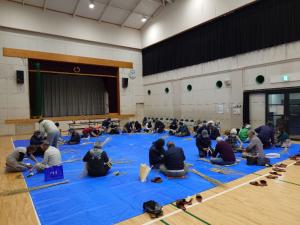 車座になってお飾りを作る受講者の写真