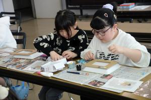 台紙に飾りをつけている写真　その1