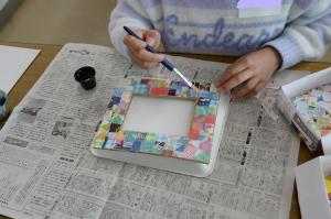 台紙に飾りをつけている写真　その2