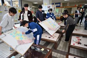 調査結果が書かれた紙を図面に貼っている写真